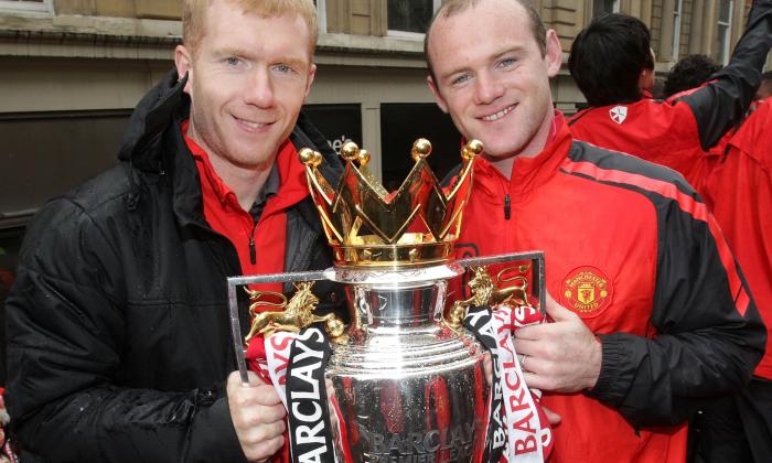 Paul Scholes and Wayne Rooney holding a trophy.