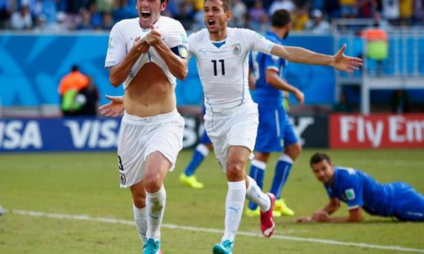 Diego Godin's late header sent Uruguay through to the last 16 of the World Cup at Italy's expense