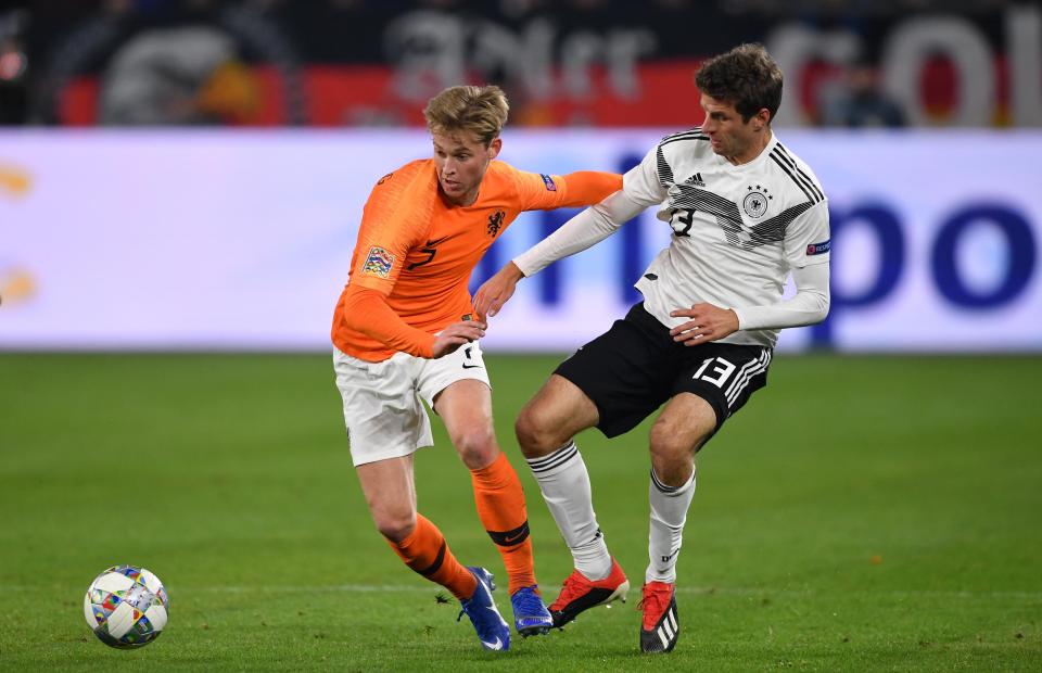  Frenkie de Jong holds off the attentions of Germany international Thomas Muller while playing for Netherlands.