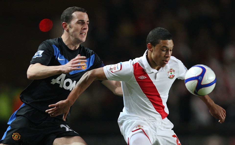  Oxlade-Chamberlain vies for possession with John O'Shea