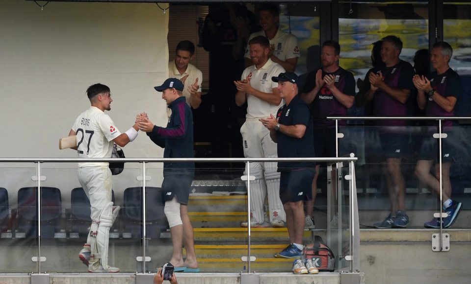  Burns celebrates with his England teammates back in the pavilion