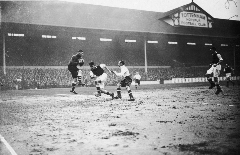  Arsenal goalkeeper Frank Moss makes a save from Tottenham striker George Hunt as defender Leslie Compton in 1935