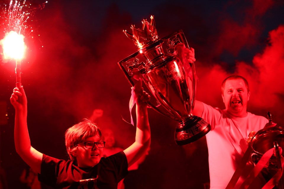  Liverpool fans celebrate at Anfield after their team clinches the Premier League title