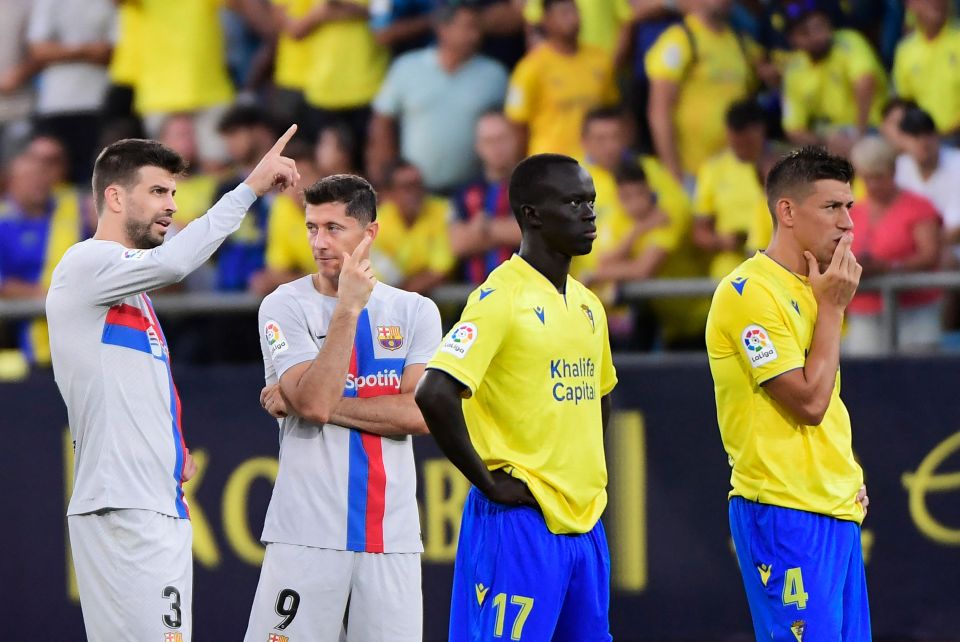 Barcelona pair Gerard Pique and Robert Lewandowski show their concern for the supporter