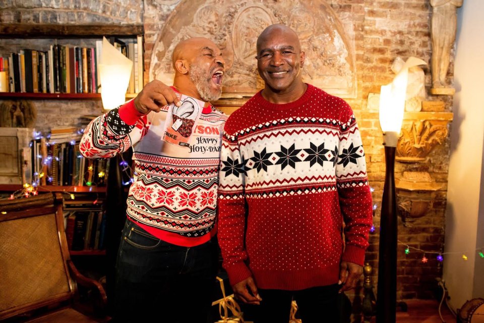 Mike Tyson and Evander Holyfield wearing Christmas sweaters.