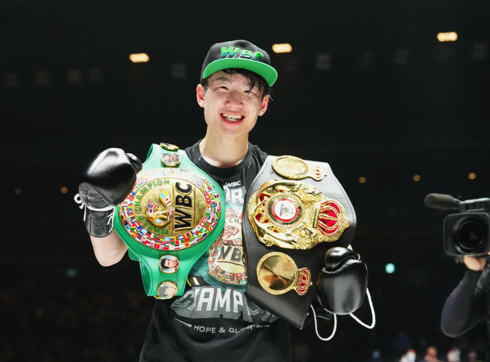 Ken Shiro Teraji holding his WBA and WBC light-flyweight world champion belts.