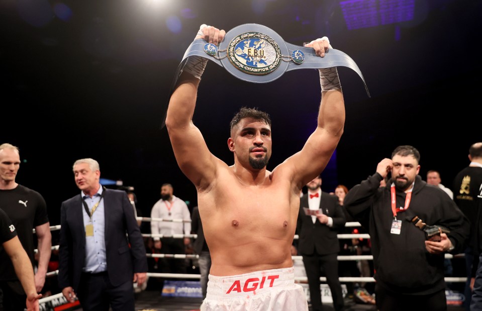 Agit Kabayel holding up a boxing championship belt.