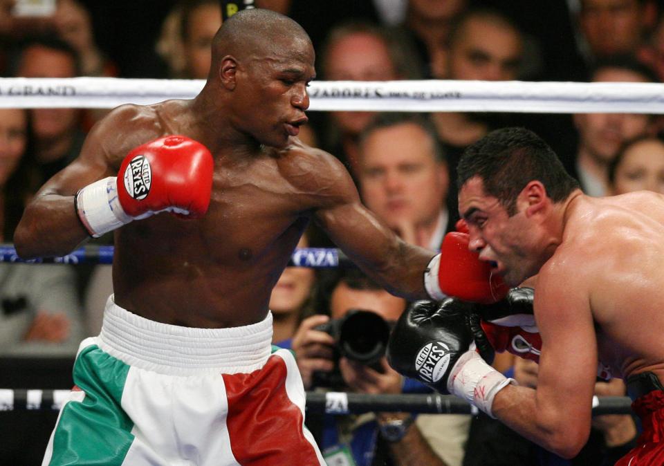 Floyd Mayweather Jr. landing a punch on Oscar De La Hoya during a boxing match.
