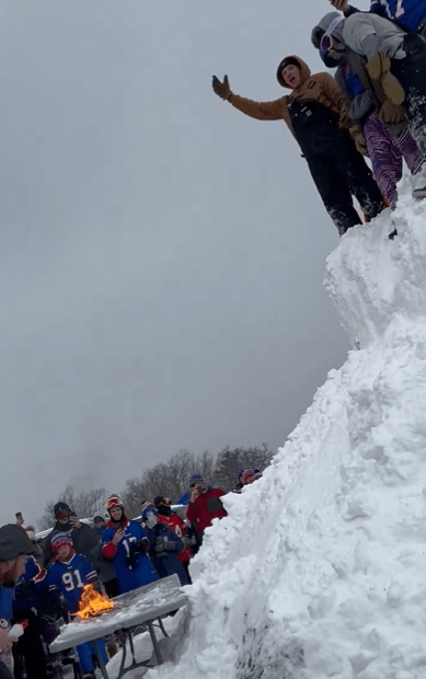 Bills Mafia members start chanting while a flaming table waits below