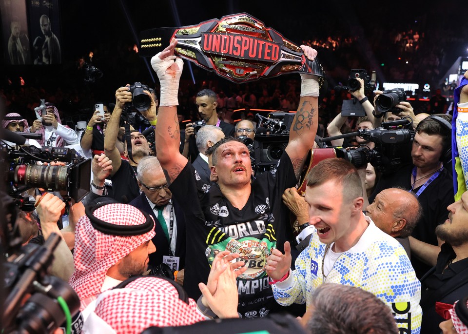 Oleksandr Usyk holding up the undisputed heavyweight championship belt.