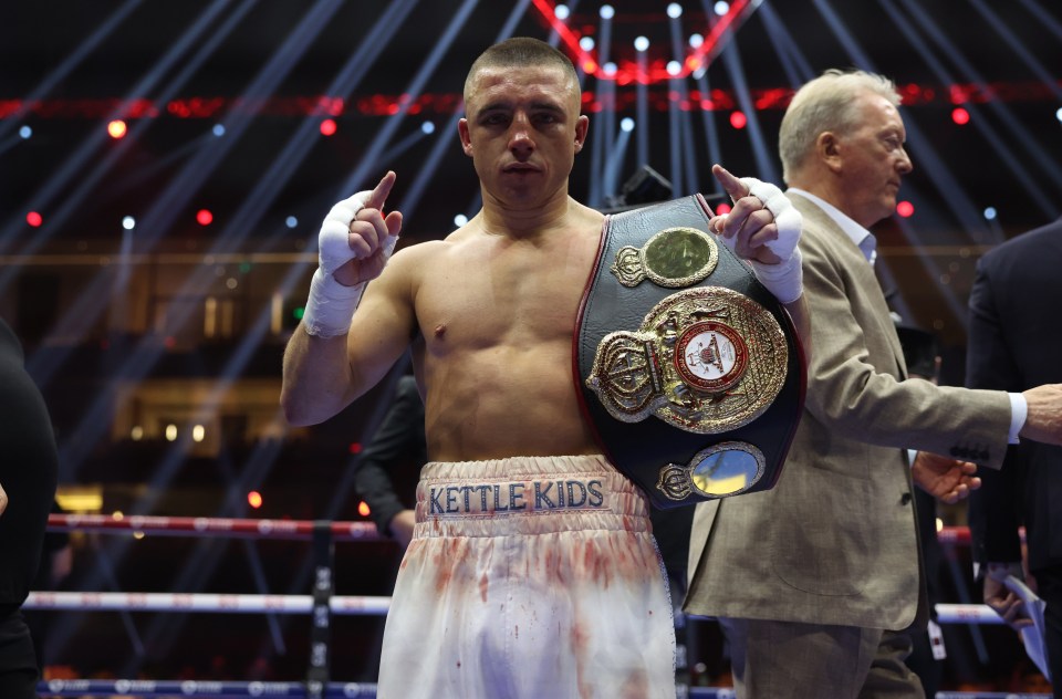 Nick Ball, WBA featherweight world champion, holding his championship belt.