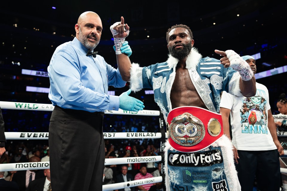 Jaron Ennis, IBF welterweight champion, with his belt and a referee.