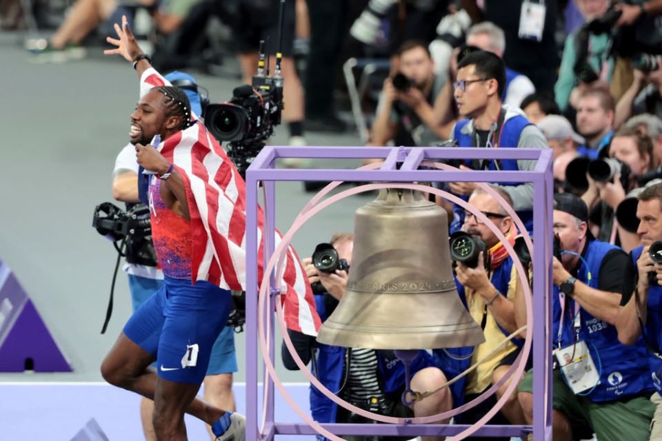 PARIS, FRANCE - AUGUST 04: Noah Lyles of Team United States celebrates next to the Paris 2024 bell after winning the gold medal in the Men's 100m Final on day nine of the Olympic Games Paris 2024 at Stade de France on August 04, 2024 in Paris, France. (Photo by Jean Catuffe/Getty Images)
