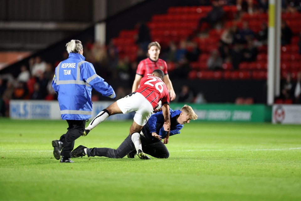 The fan was tackled by Okagbue before stewards escorted him away