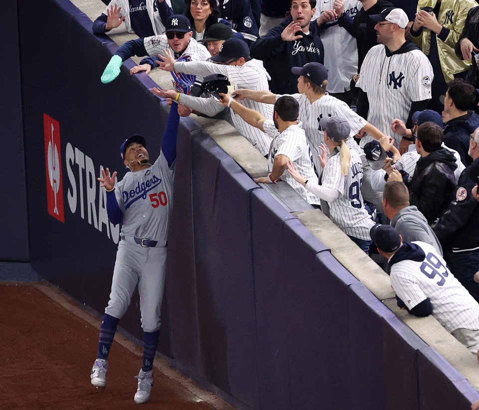 Mookie Betts tries to make a catch and fight off New York Yankees fans in right field