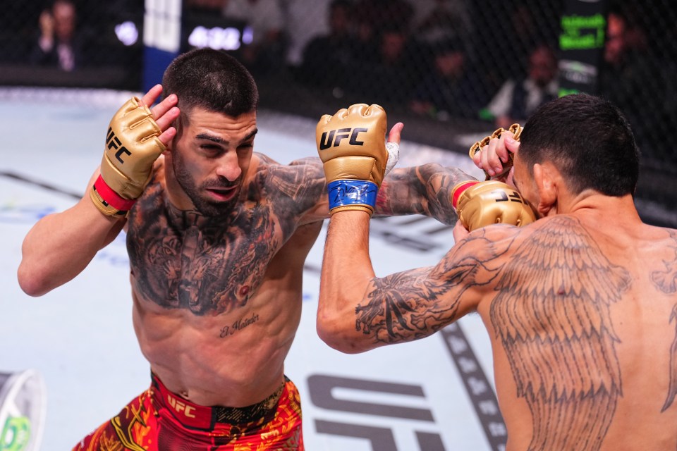 ABU DHABI, UNITED ARAB EMIRATES - OCTOBER 26: (L-R) Ilia Topuria of Spain punches Max Holloway in the UFC featherweight championship fight during the UFC 308 event at Etihad Arena on October 26, 2024 in Abu Dhabi, United Arab Emirates.  (Photo by Chris Unger/Zuffa LLC)