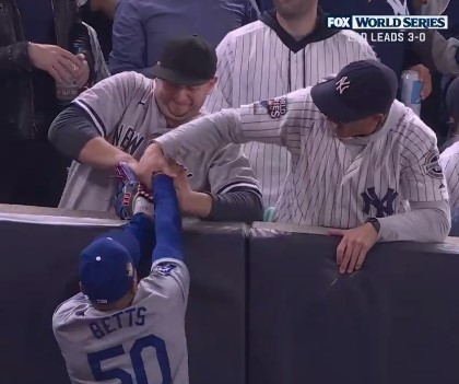 Two Yankees fans grabbed his glove and right arm