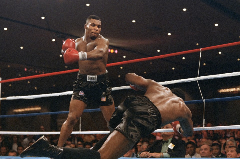 Heavyweight champion Trevor Berbick goes down after a hard left from challenger Mike Tyson in the 2nd round of their scheduled 12 round WBC title bout at the Las Vegas Convention Center on November 22, 1986. Tyson won the fight by knockout in 2:35 of the second round to become the youngest heavyweight champion of the world in history at 20. (Photo by Carlos SCHIEBECK / AFP) (Photo by CARLOS SCHIEBECK/AFP via Getty Images)