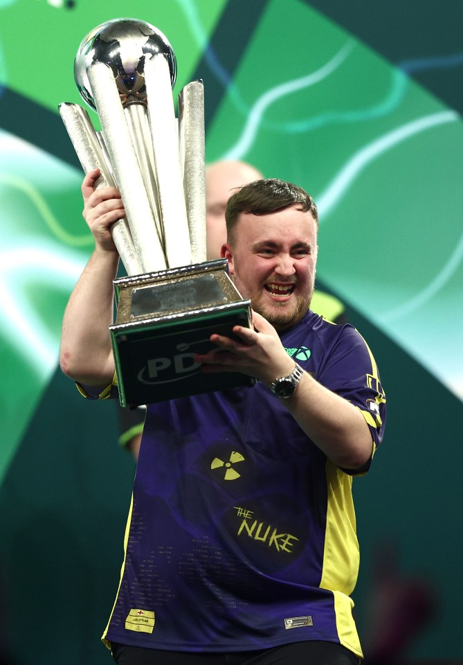 LONDON, ENGLAND - JANUARY 03: Luke Littler of England lifts the trophy as he celebrates winning the Final against Michael van Gerwen of The Netherlands during day sixteen of the 2024/25 Paddy Power World Darts Championship at Alexandra Palace on January 03, 2025 in London, England. (Photo by James Fearn/Getty Images)