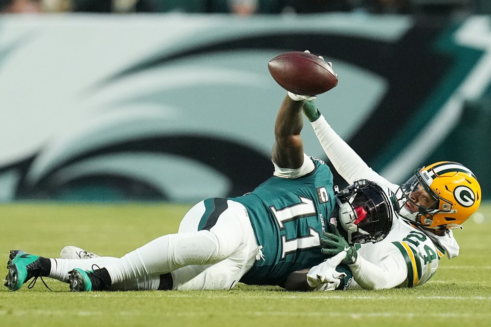 PHILADELPHIA, PENNSYLVANIA - JANUARY 12: A.J. Brown #11 of the Philadelphia Eagles catches a pass in front of Carrington Valentine #24 of the Green Bay Packers in the first quarter during the NFC Wild Card Playoff at Lincoln Financial Field on January 12, 2025 in Philadelphia, Pennsylvania.  (Photo by Mitchell Leff/Getty Images)