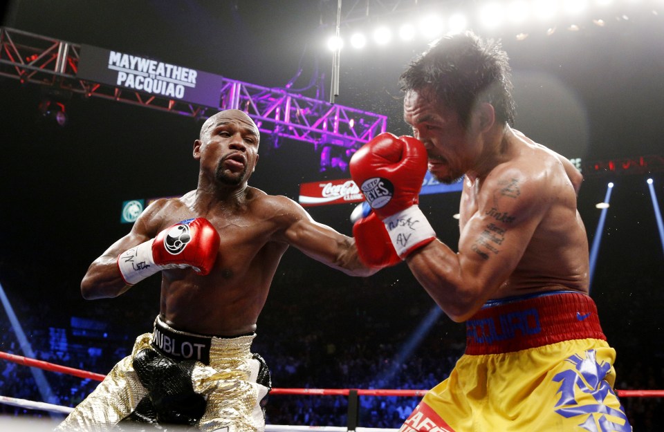Floyd Mayweather Jr. exchange punches with Manny Pacquiao during their welterweight unification championship bout, May 2, 2015 at MGM Grand Garden Arena in Las Vegas, Nevada.  Mayweather defeated Pacquiao by unanimous decision.  AFP PHOTO / JOHN GURZINKSI        (Photo credit should read JOHN GURZINSKI/AFP via Getty Images)