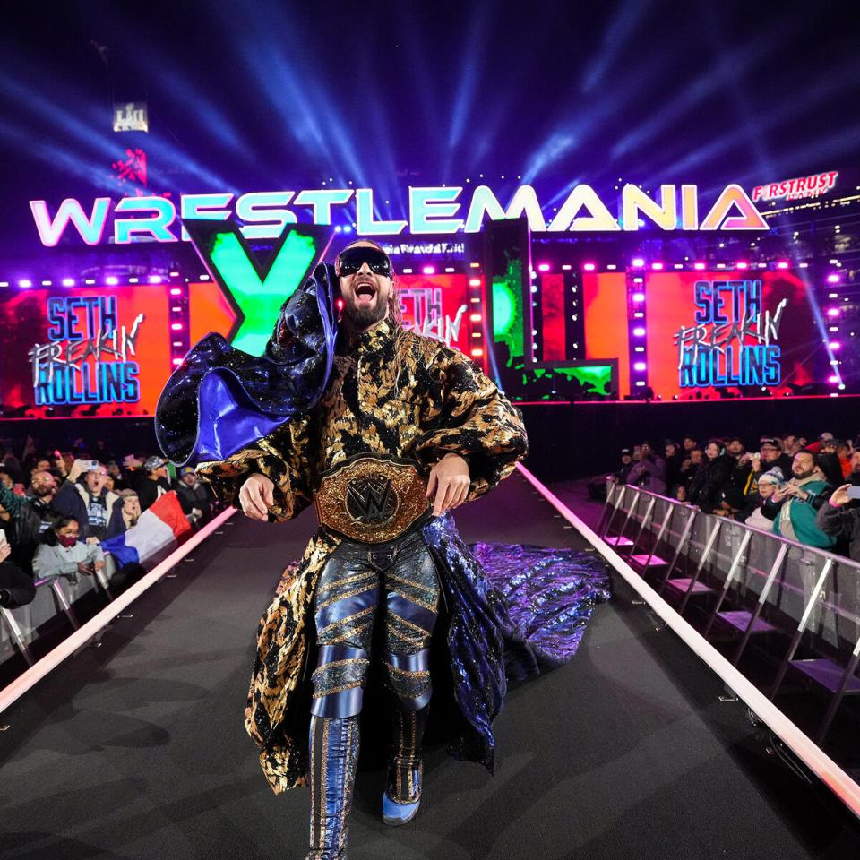 Seth Rollins at WrestleMania, holding a championship belt.