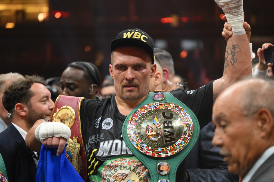 Oleksandr Usyk, the undisputed heavyweight boxing champion, holding championship belts.