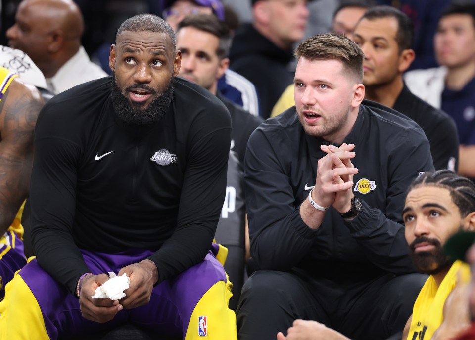 LeBron James and a Lakers staff member sitting courtside.