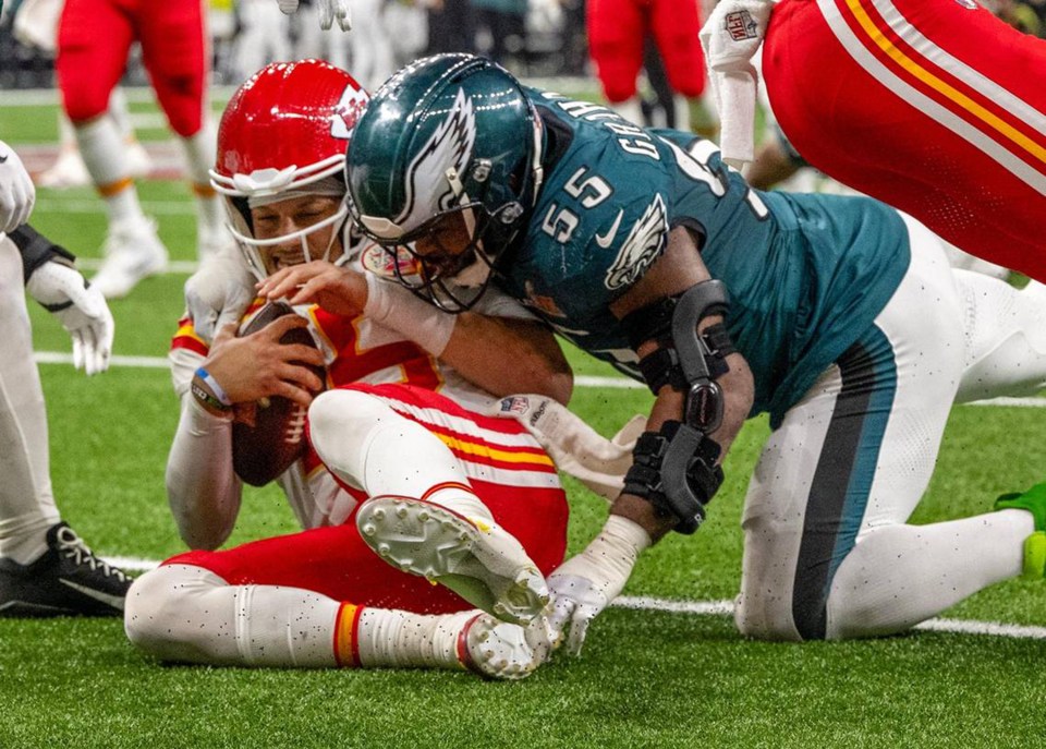 Kansas City Chiefs quarterback Patrick Mahomes (15) slides and his tackled by Philadelphia Eagles defensive end Brandon Graham (55) in Super Bowl LIX on Sunday, Feb. 9, 2025, in New Orleans. (Tammy Ljungblad/The Kansas City Star/Tribune News Service via Getty Images)