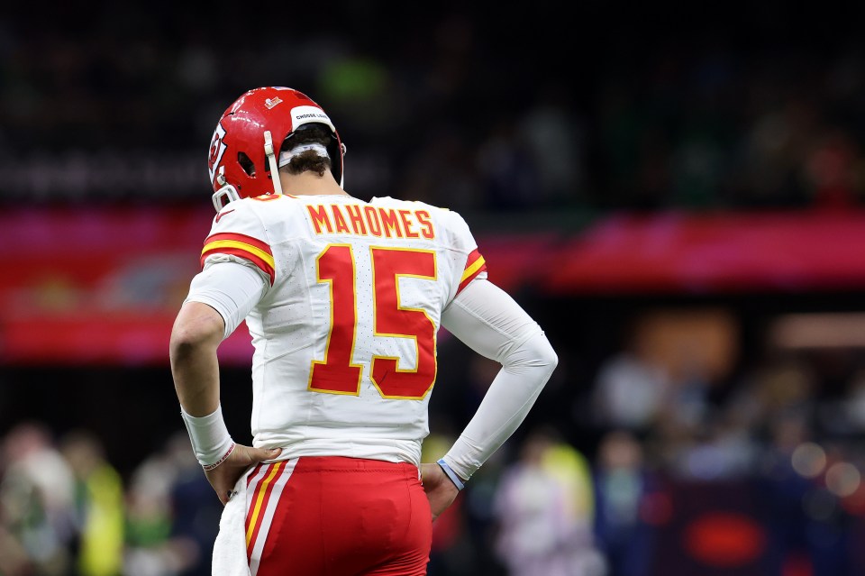 Patrick Mahomes, #15, with his back to the camera on a football field.