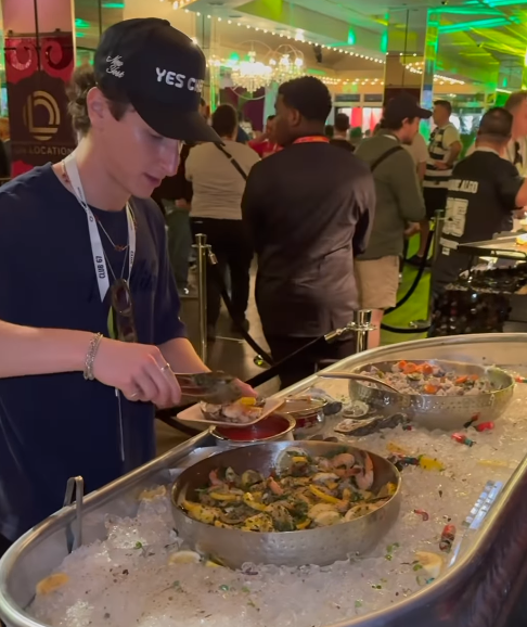 Person serving themselves seafood at a buffet.