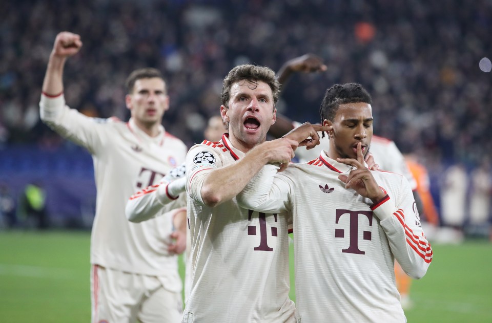 Michael Olise and Thomas Müller of FC Bayern München celebrating a goal.
