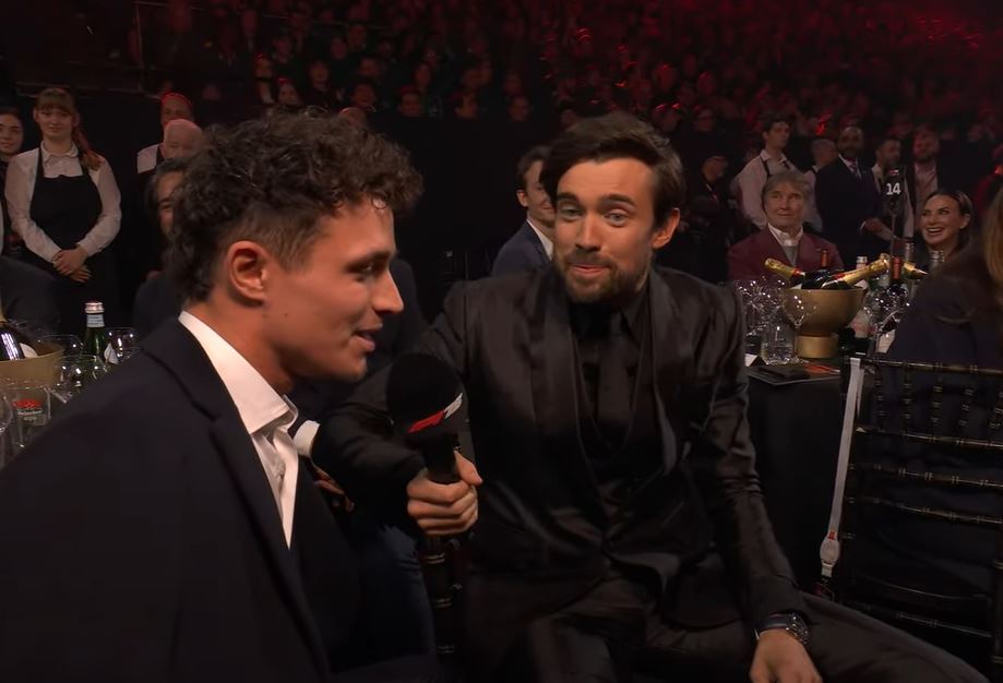Two men in suits being interviewed.