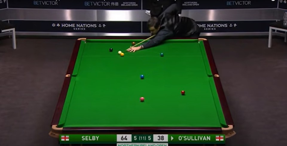 Ronnie O'Sullivan lining up a snooker shot.