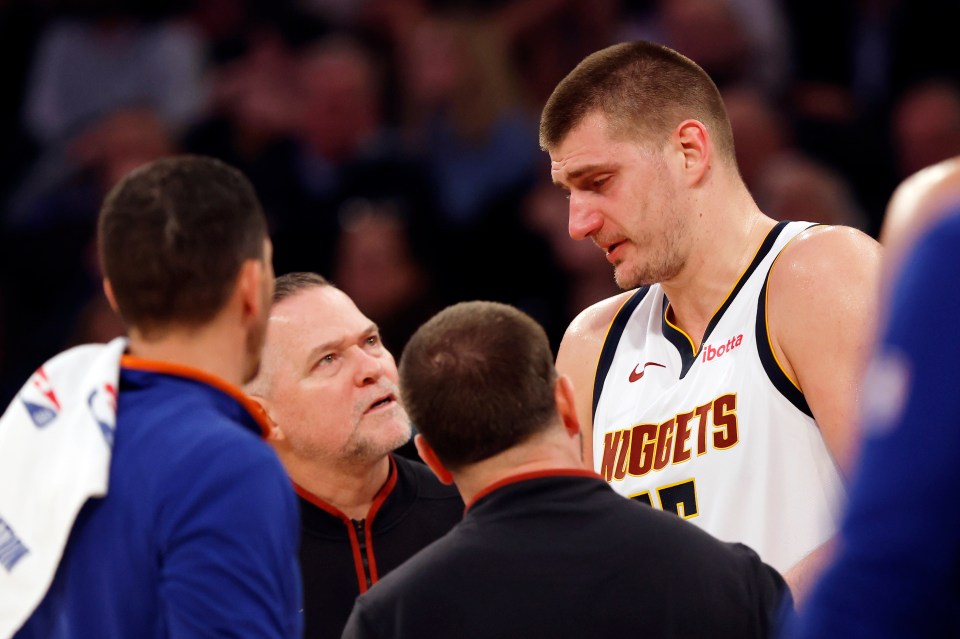 NEW YORK, NEW YORK - JANUARY 25: Nikola Jokic #15 reacts with head coach Michael Malone of the Denver Nuggets after an injury to his eye during the first half against the New York Knicks at Madison Square Garden on January 25, 2024 in New York City. NOTE TO USER: User expressly acknowledges and agrees that, by downloading and/or using this Photograph, user is consenting to the terms and conditions of the Getty Images License Agreement. (Photo by Sarah Stier/Getty Images)