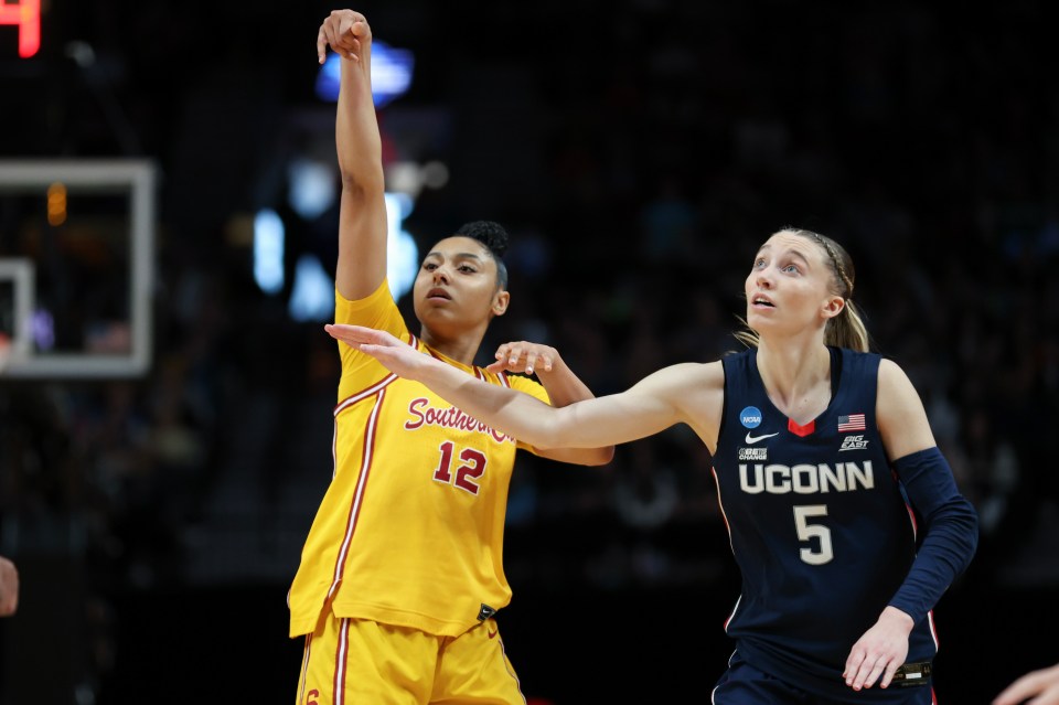 PORTLAND, OREGON - APRIL 01: JuJu Watkins #12 of the USC Trojans and Paige Bueckers #5 of the Connecticut Huskies watch a shoot during the first half in the Elite 8 round of the NCAA Women's Basketball Tournament at Moda Center on April 01, 2024 in Portland, Oregon. (Photo by Steph Chambers/Getty Images)