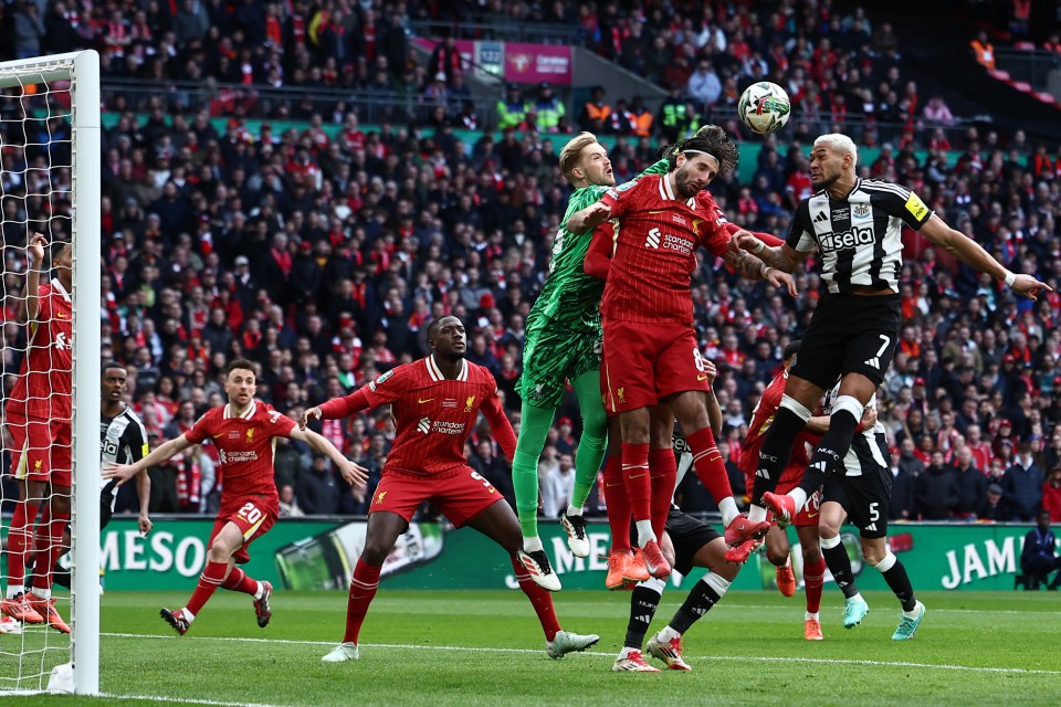 Liverpool's Irish goalkeeper #62 Caoimhin Kelleher (C) punches the ball under pressure from Newcastle United's Brazilian midfielder #07 Joelinton (R) and Liverpool's Hungarian midfielder #08 Dominik Szoboszlai (2R) during the English League Cup final football match between Liverpool and Newcastle United at Wembley Stadium, north-west London on March 16, 2025. (Photo by HENRY NICHOLLS / AFP) / RESTRICTED TO EDITORIAL USE. No use with unauthorized audio, video, data, fixture lists, club/league logos or 'live' services. Online in-match use limited to 120 images. An additional 40 images may be used in extra time. No video emulation. Social media in-match use limited to 120 images. An additional 40 images may be used in extra time. No use in betting publications, games or single club/league/player publications. /  (Photo by HENRY NICHOLLS/AFP via Getty Images)