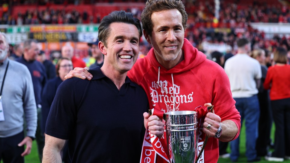 Rob McElhenney and Ryan Reynolds lifted the promotion trophy on the pitch